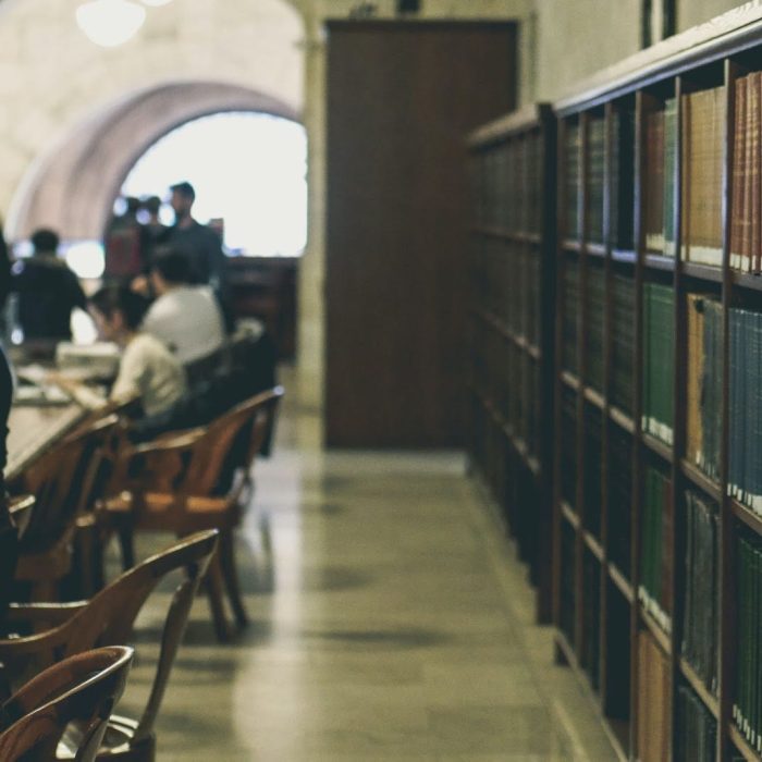 people working at long desks in a historic library